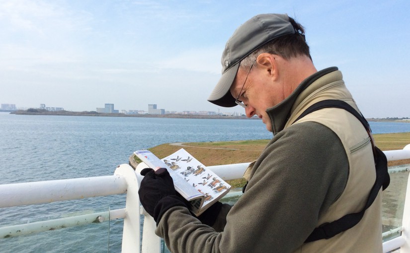 Craig Brelsford consulting Birds of East Asia at Dishui Lake, Shanghai, 28 Nov. 2015. Photo by Elaine Du.